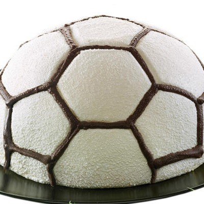 slaščica torta v obliki nogometne žoge na črnem okroglem krožniku