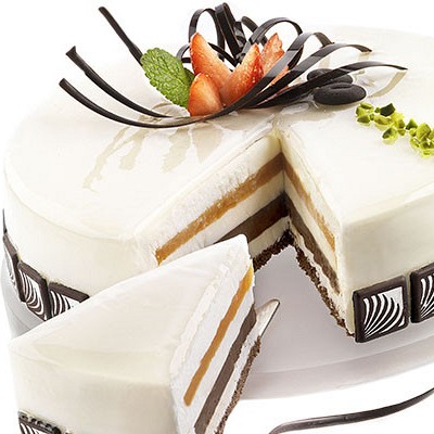 okrogla torta z belim svetlečim prelivom in čokoladno dekoracijo