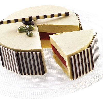 okrogla torta prelita z belo čokolado in okrašena s kvadratnimi dodatki