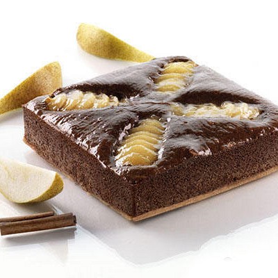 kvadratna torta okrašena z rezinami hruške in čokoladnim prelivom